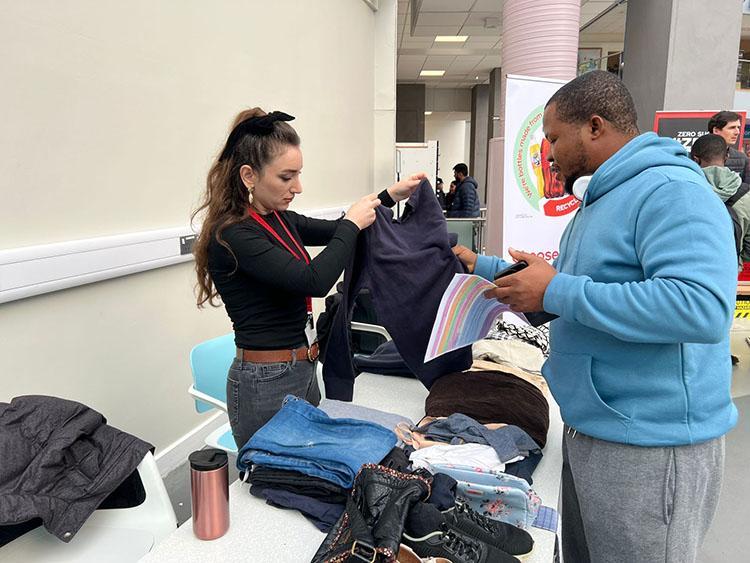 Student taking pre loved clothes form the member of student society