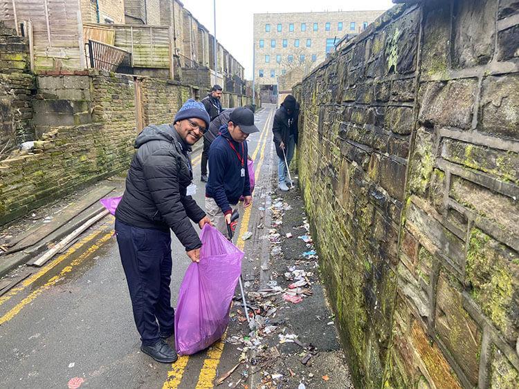 Students cleaning litter from the street near campus