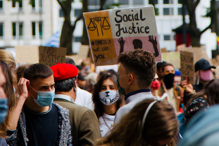 Protestors in London holding a 'Social Justice' sign.