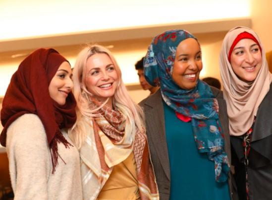 Four women of mixed race smiling