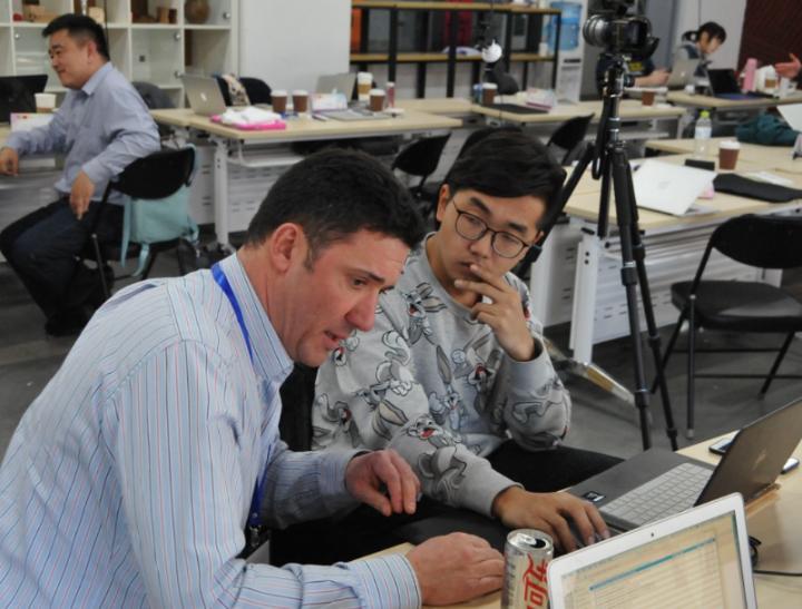 A student and a member of staff sat together in an Open Innovation workshop.